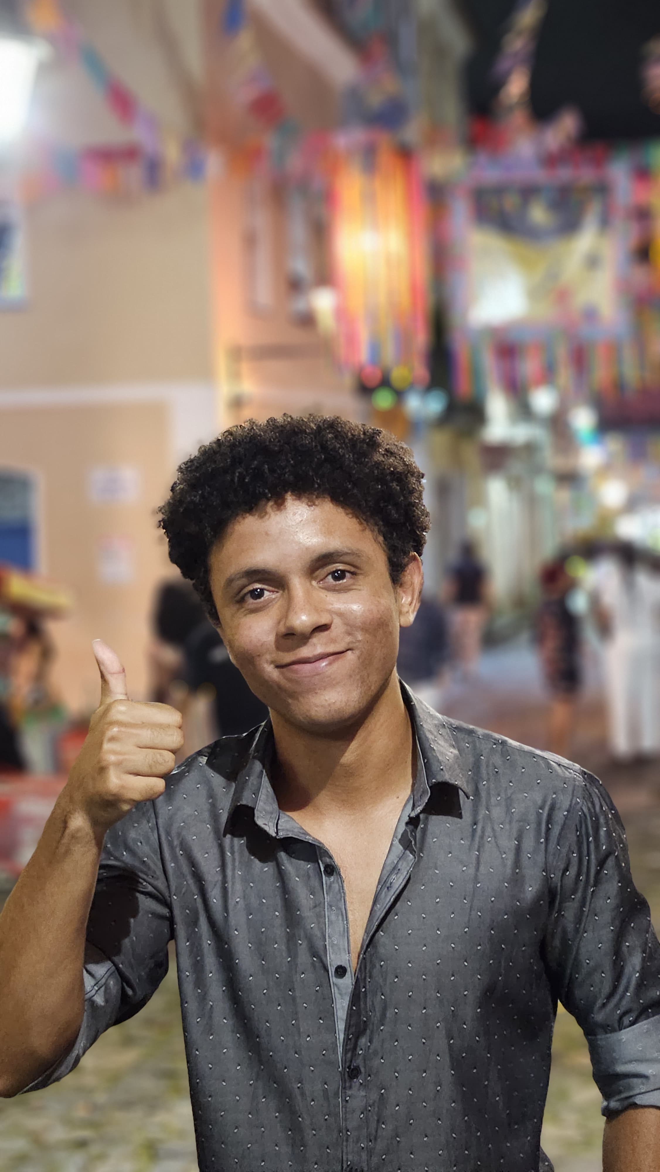 Matheus sorrindo e acenando para a câmera nas ruas de Salvador